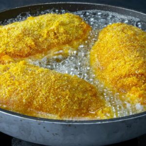 With corn flour! Try to cook chicken breast like this and you will not regret it